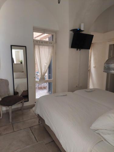 a bedroom with a bed and a mirror and a chair at Legatia in Jerusalem