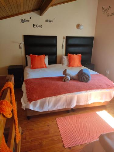 a bedroom with two large beds with orange pillows at LightStone Guesthouse in Centurion