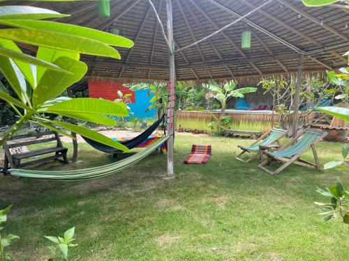 a patio with a hammock and chairs under a tent at Freedom home in Ko Chang