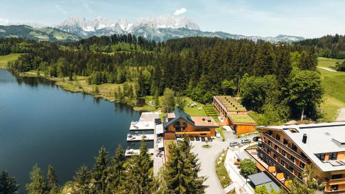 an aerial view of a resort with a lake and mountains at Alpenhotel Kitzbühel am Schwarzsee - 4 Sterne Superior in Kitzbühel