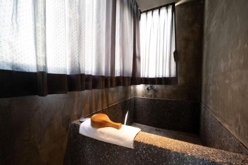 a bathroom with a bath tub with a roll of toilet paper at Yunoyado Onsen Hot Spring Hotel Deyang in Jiaoxi