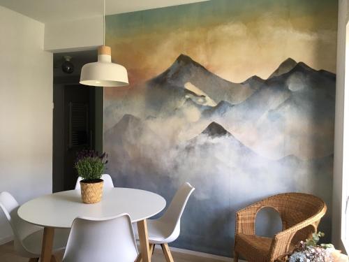 ein Esszimmer mit einem Tisch und einem Wandbild der Berge in der Unterkunft El Cau de Ribes in Ribes de Freser