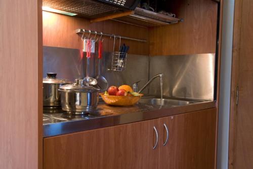 a kitchen with a sink and a bowl of fruit at George Studios in Yenion