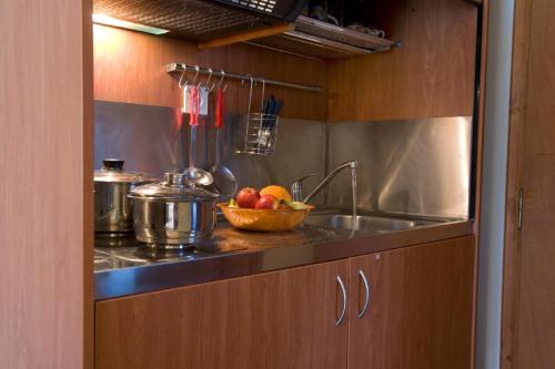 a kitchen with a sink and a bowl of fruit at George Studios in Yénion