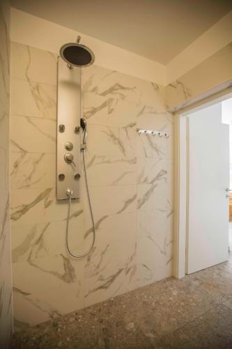 a shower in a bathroom with a marble wall at Apartment Mery in Pula