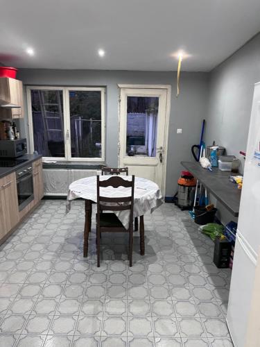 a kitchen with a table with a chair in it at Grande maison avec plusieurs chambres à louer in Liège