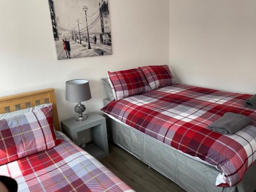 a bedroom with two beds and a lamp on a night stand at Rooms in Inverness in Inverness