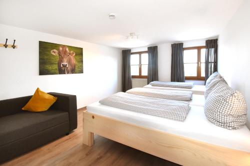 a bedroom with two beds and a couch at Alps Hostel in Pfronten
