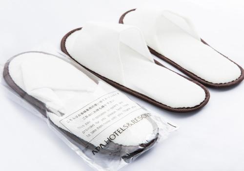 a pair of white flip flops in a plastic bag at APA Hotel Sakai Ekimae in Sakai