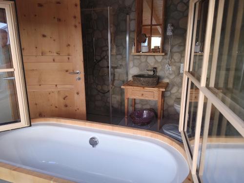 eine weiße Badewanne im Bad mit Dusche in der Unterkunft Hotel Crusch Alba Sta Maria in Sta Maria Val Müstair