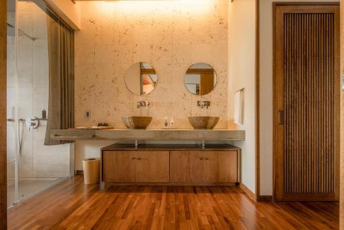 a bathroom with two sinks and two mirrors at Sesoko Sansui in Sesoko