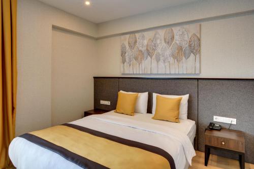 a bedroom with a large bed with yellow pillows at Leo Suites in Bursa