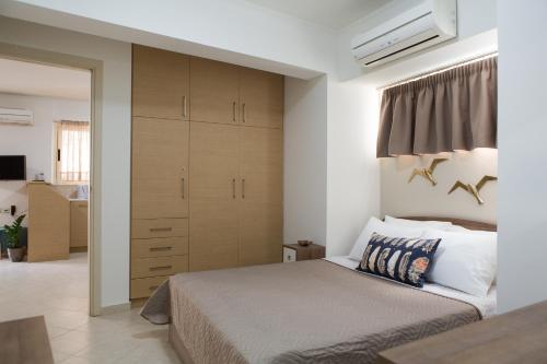 a bedroom with a bed and a large closet at Anemone City Center Apartment in Heraklio
