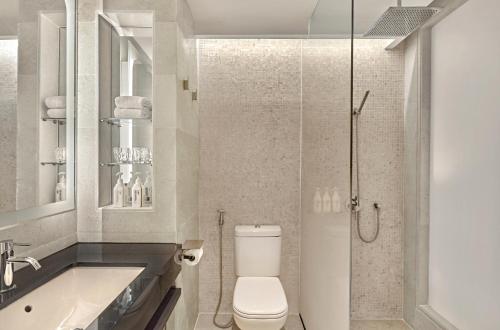 a bathroom with a toilet and a sink and a shower at Vibe Hotel Singapore Orchard in Singapore