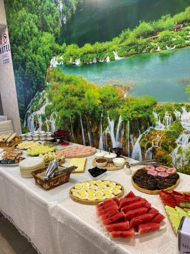 a table with food and a painting of a waterfall at Hotel Sharl in Ninotsminda