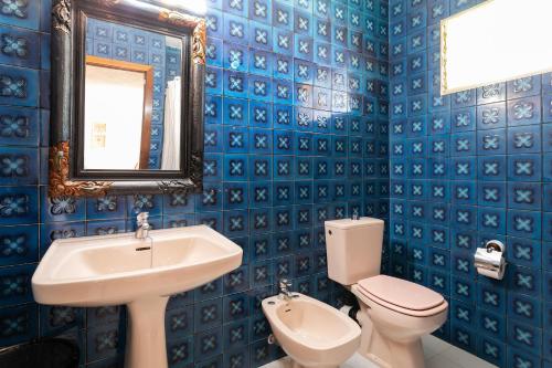 a blue tiled bathroom with a sink and a toilet at Casa La Roqueta in Guardamar del Segura