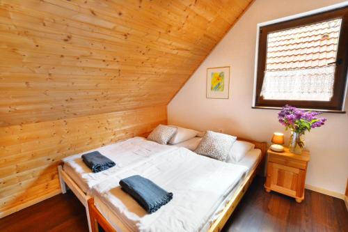uma cama num quarto com uma parede de madeira em Domki Gościniec Bobolin em Bobolin