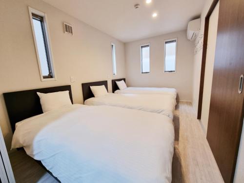 東京にあるLien 西新宿の窓のある小さな部屋にベッドが2つある