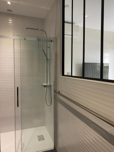 La salle de bains est pourvue d'une douche en verre et d'une fenêtre. dans l'établissement Sainte Maxime Appartement 1 pièce, à Sainte-Maxime