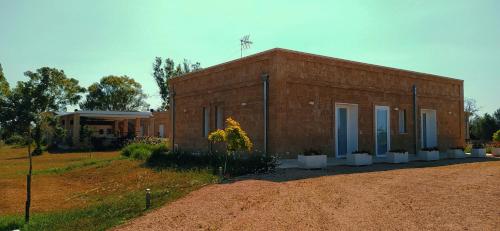 a brick building with plants in front of it at Residenza Case Arse in Torre Lapillo
