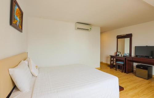 a bedroom with a bed and a desk with a television at ALUNA Ben Thanh Hotel in Ho Chi Minh City