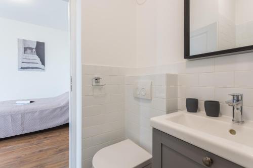 un bagno con lavandino, WC e letto di BU2 Pula Studio Apartment a Pola (Pula)