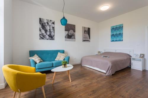 una camera con un letto, un divano blu e un tavolo di BU2 Pula Studio Apartment a Pola (Pula)