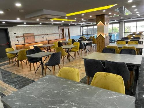 une salle à manger avec des tables et des chaises jaunes dans l'établissement Grand Nergiz Otel, à Antalya