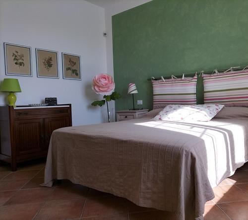 een slaapkamer met een groot bed met een roze roos bij Casaserena in San Vincenzo