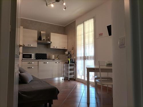 een keuken met witte kasten en een tafel in een kamer bij Casaserena in San Vincenzo