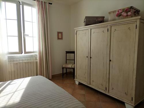 een slaapkamer met een bed en een grote houten kast bij Casaserena in San Vincenzo