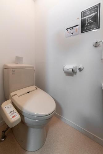a bathroom with a white toilet in a room at ETAVIA Yufuin Kinrinko in Yufuin