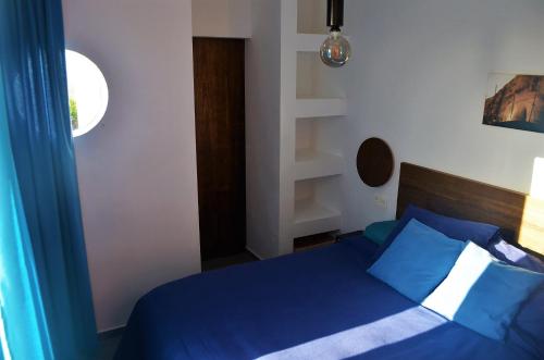 a bedroom with a blue bed with blue pillows at EL REFUGIO in Famara