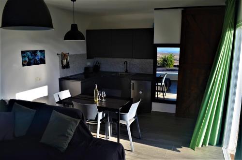 cocina y sala de estar con mesa y comedor en EL REFUGIO, en Famara