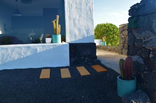 a cross on the ground in front of a house with cactus at EL REFUGIO in Famara
