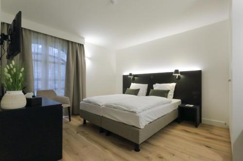 a bedroom with a large bed and a window at Corsendonk Hooge Heyde in Lichtaart