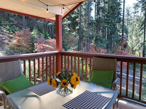a table and chairs on a deck with trees at YoBee! Park Reservation Included! Heart of Yosemite - Homey Studios and Breakfast in Yosemite West