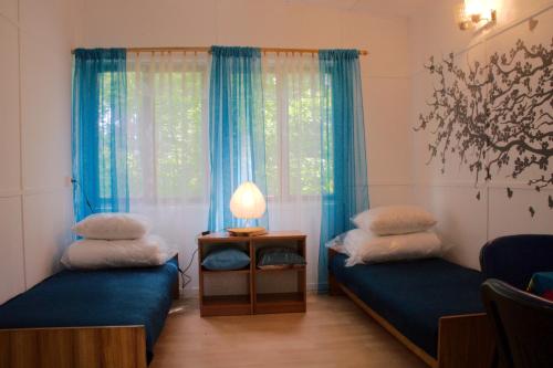 Pokój z 2 łóżkami i stołem z lampką w obiekcie Ośrodek Wypoczynkowy Warmia w mieście Butryny
