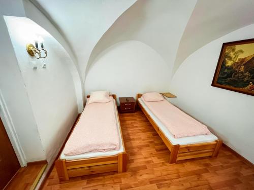 2 camas en una habitación pequeña con una pintura en Noclegi WOKU, en Świebodzice