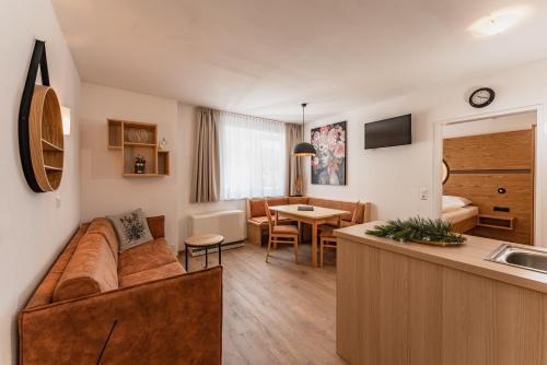 ein Wohnzimmer mit einem Sofa und einer Küche in der Unterkunft ''die Bergerin'' | Appartements Schladming in Schladming