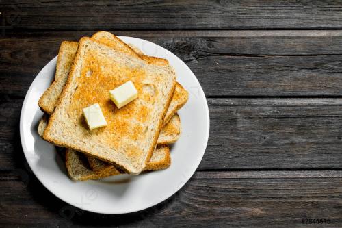 two slices of toast with butter on a plate on a table at Hotel Malad Inn opposite Malad Railway Station in Mumbai