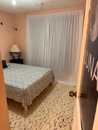 a bedroom with a bed and a white curtain at Casa Estelar in Cancún