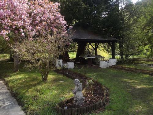 a garden with a gazebo and a tree with pink flowers at PROPRIETE BORDEE D'ETANGS, PROPICE A LA DETENTE in Florenville