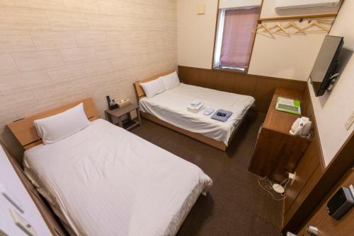 a hospital room with two beds and a mirror at ETAVIA Yufuin Kinrinko in Yufuin