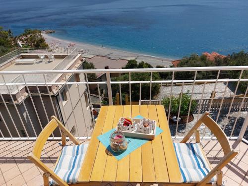 a yellow table on a balcony with a view of the ocean at Una finestra sul mare Home 1 in Bergeggi