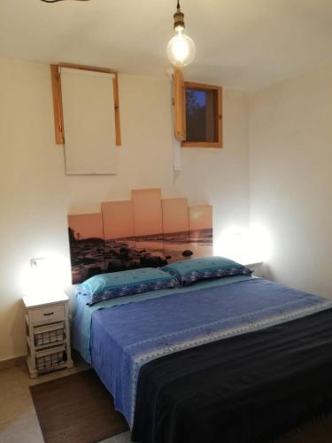 a bedroom with a large bed with a blue blanket at Ciao b&b in Selva di Fasano
