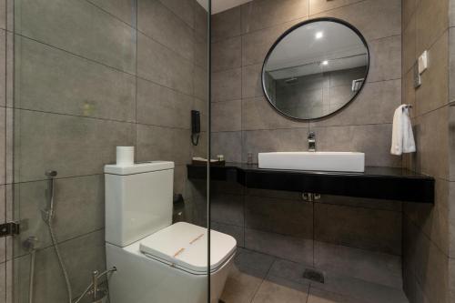a bathroom with a toilet and a sink and a mirror at MaRadha Colombo in Colombo