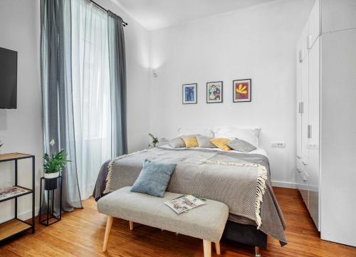 a white bedroom with a bed and a chair at Berry Berry Studios by Flat White in Zagreb