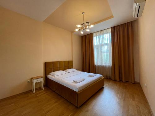 sypialnia z łóżkiem i dużym oknem w obiekcie Avangard on Qn Romana St 26 Apart w Lwowie