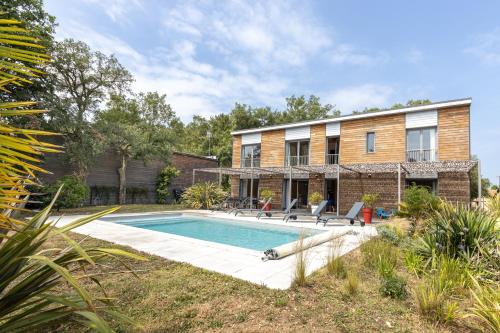 une maison avec une piscine dans la cour dans l'établissement Santos Villa Piscine Proche Plage, à Moliets-et-Maa